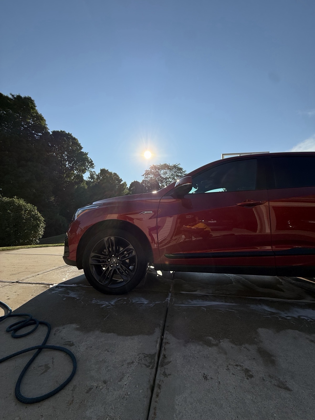 Red SUV side profile after an exterior detail, sun catching the paint