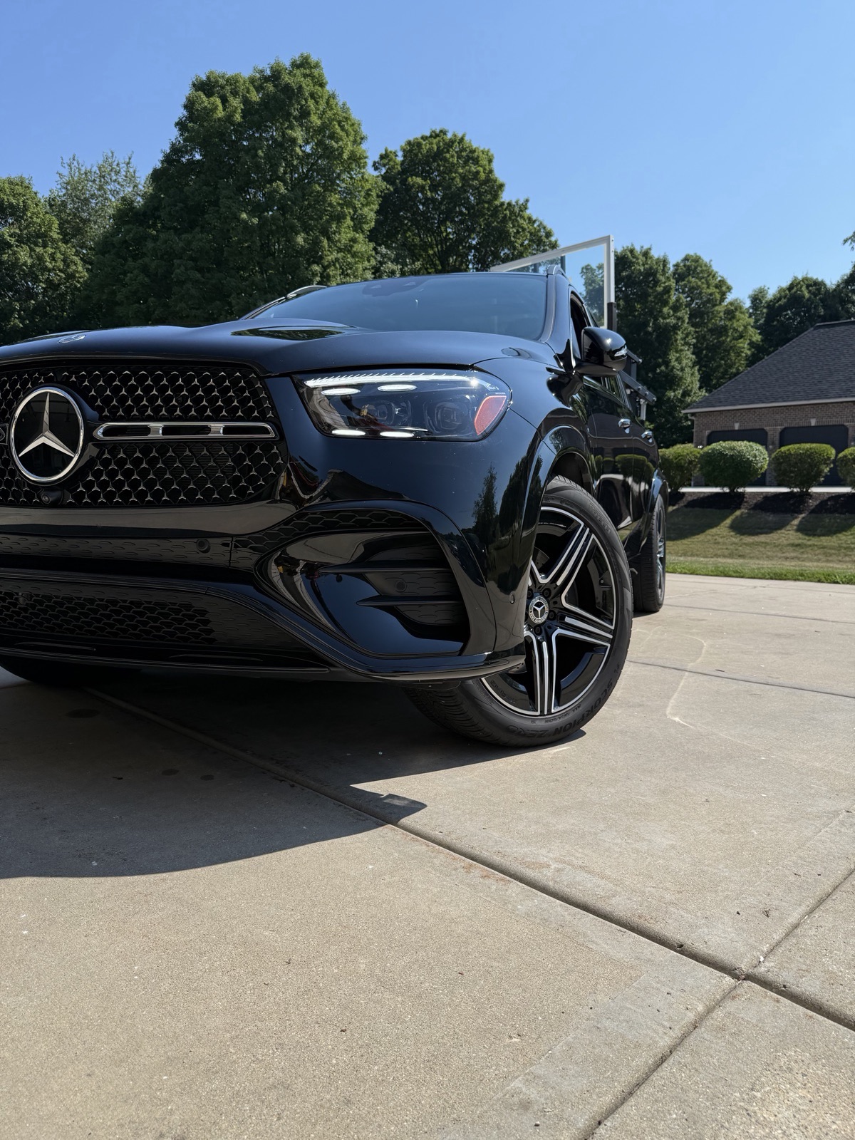 Black Mercedes front end after detailing, grille and headlights gleaming